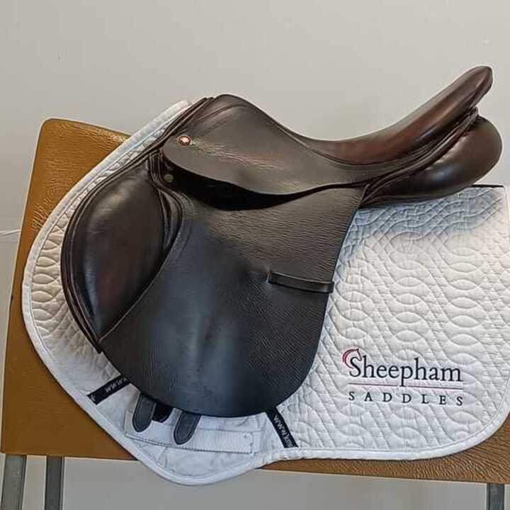 Albion 17" Jump MW Brown rests on a white saddle pad on a wooden chair.